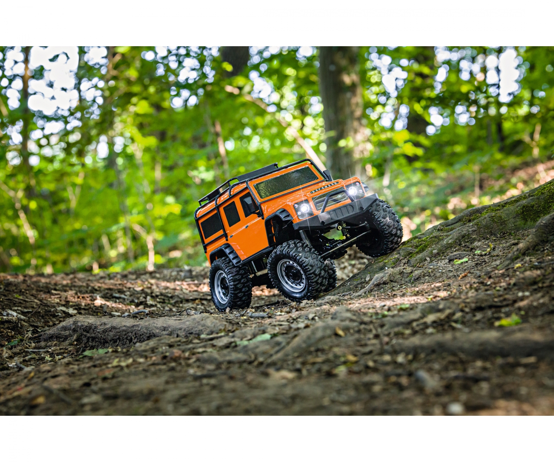 carson-500404171-3-Land-Rover-Defender-100-RTR-orange-Rock-Crawler-in-Action